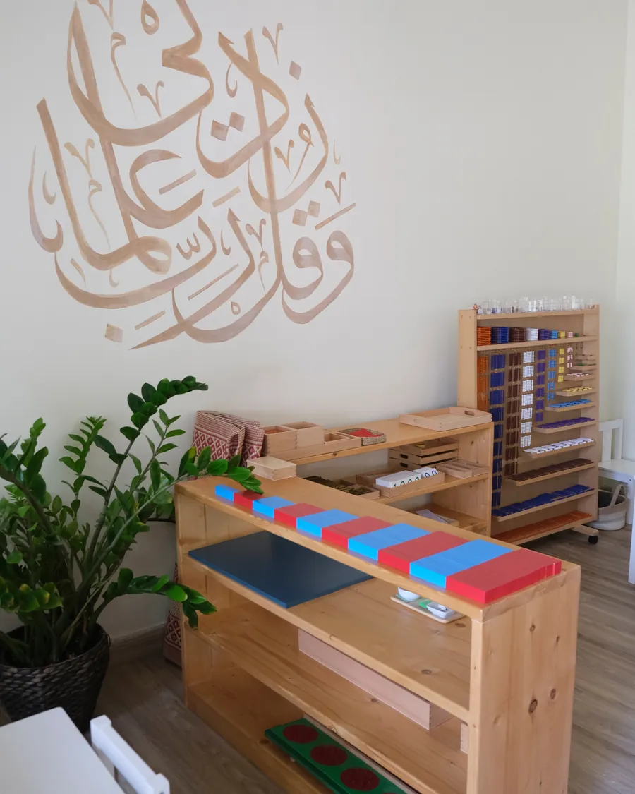 Arabic calligraphy on the wall beside Montessori materials
