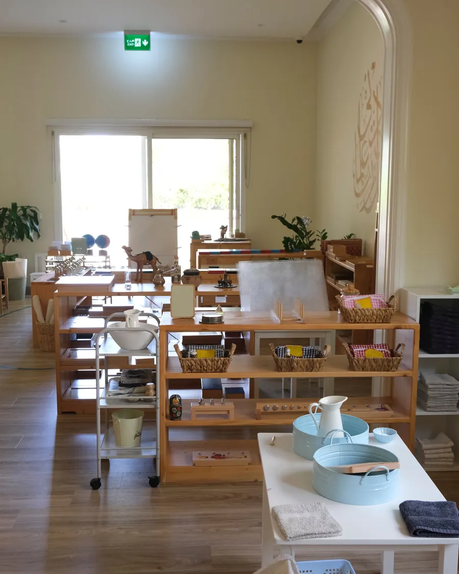 A bright Montessori classroom with low wooden shelves