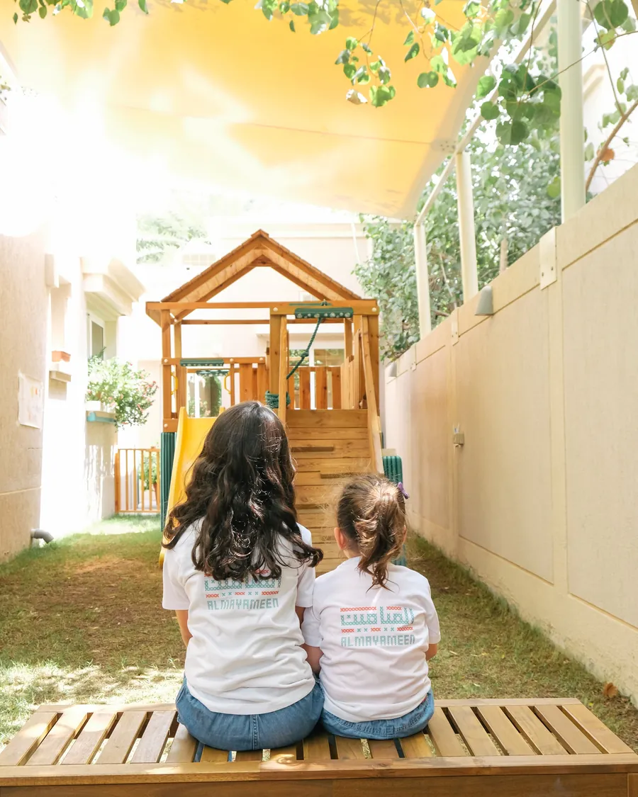 Two children in the AlMayameen garden in warm afternoon light
